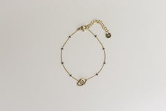 Gouden armband met verbonden hartjes en zwarte kraaltjes