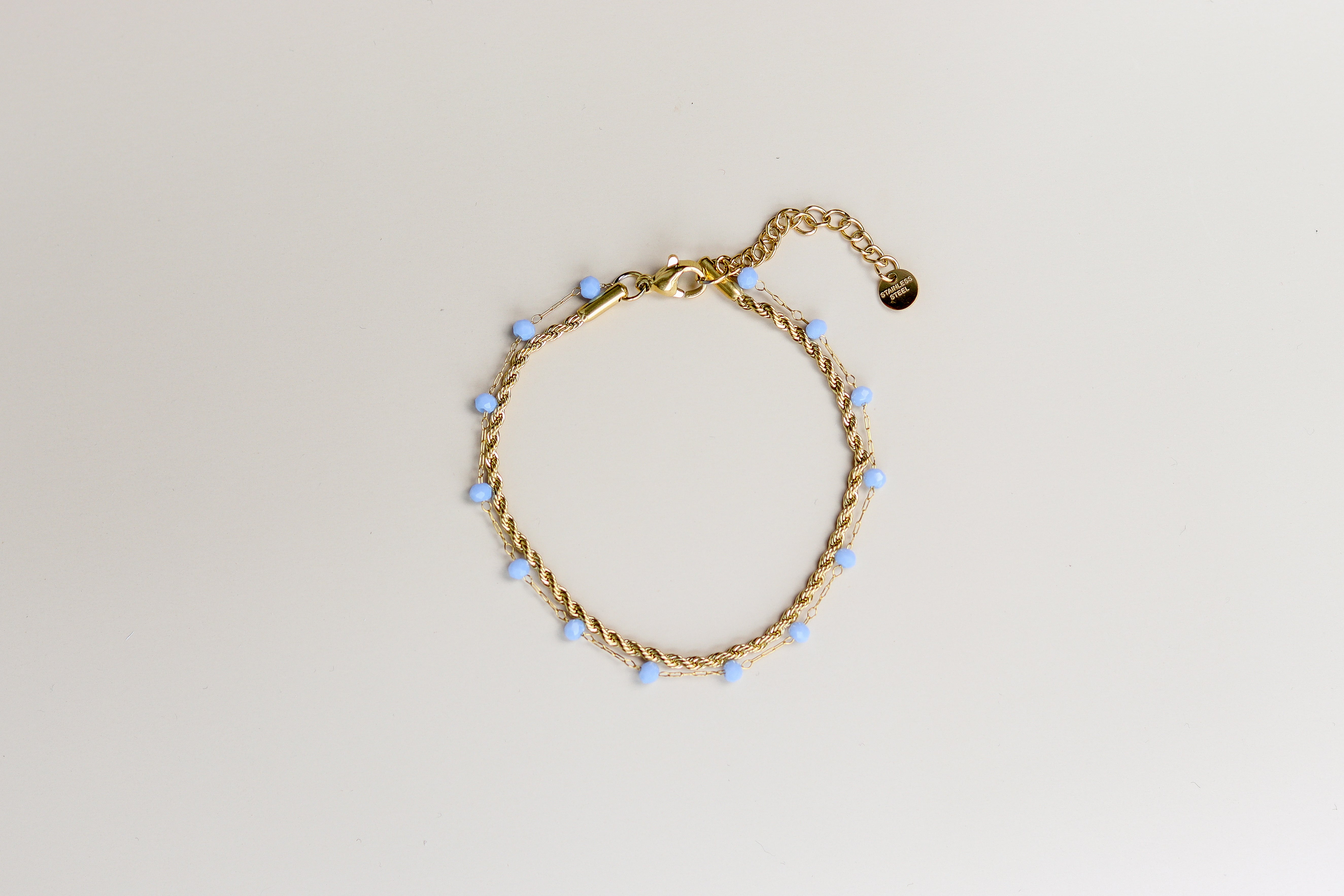 Gouden dubbele armband met blauwe kraaltjes en verlengstukje