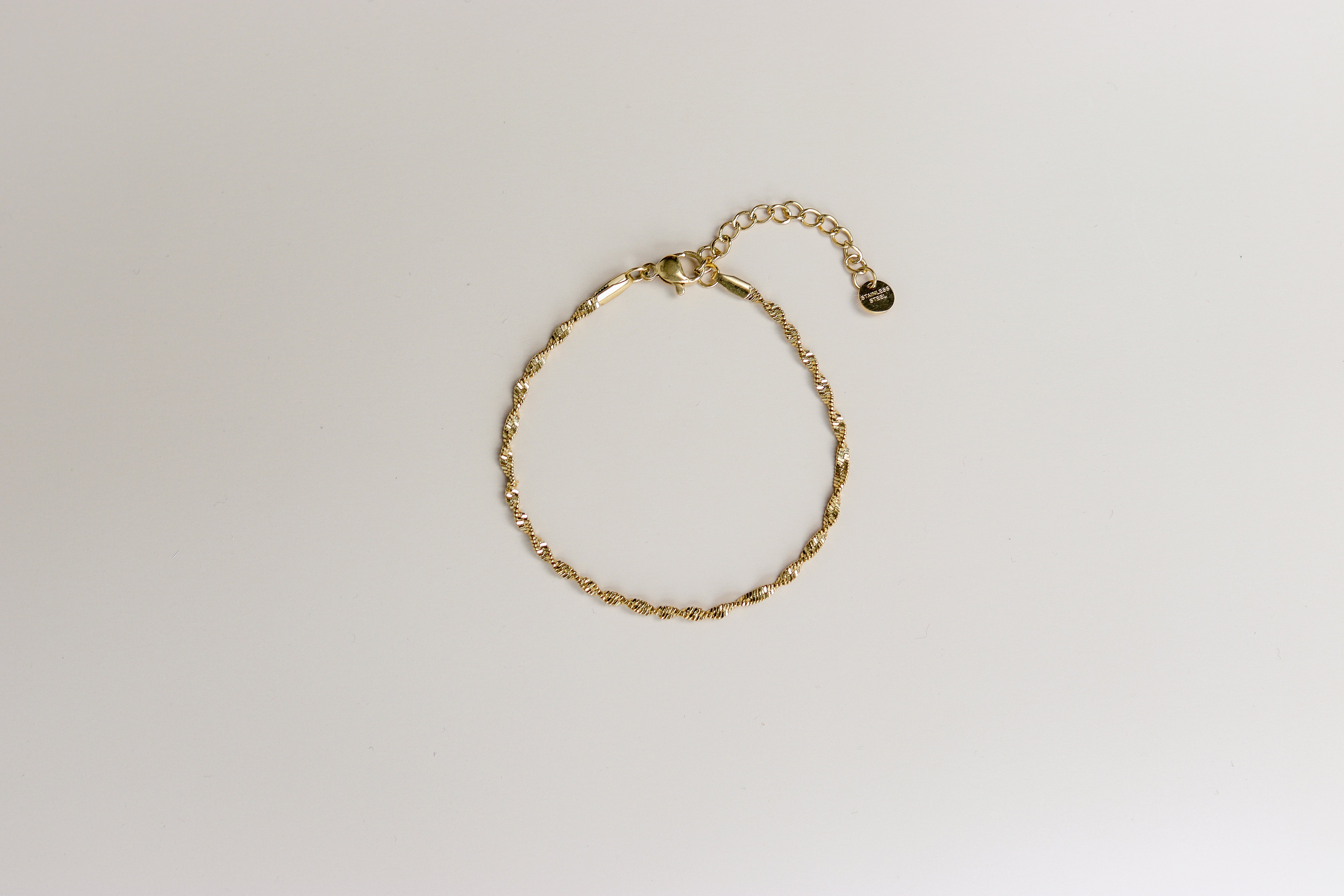 Gouden plat gedraaide armband met verlengstukje