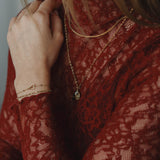 Armband met verbonden hartjes en zwarte kraaltjes-goud